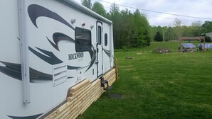 A white RV with "Rockwood UltraLite" branding parked on a grassy field. - Casa Coqui Camper, with WiFi, & AC, 3 miles from Falls Creek Falls State Park (Pikeville)
