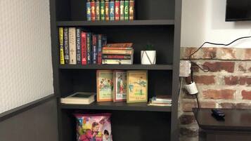 A bookshelf with various books and a small plant.