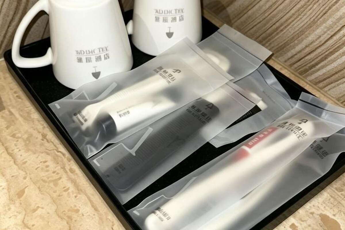 A tray with two white mugs and several skincare product packages.