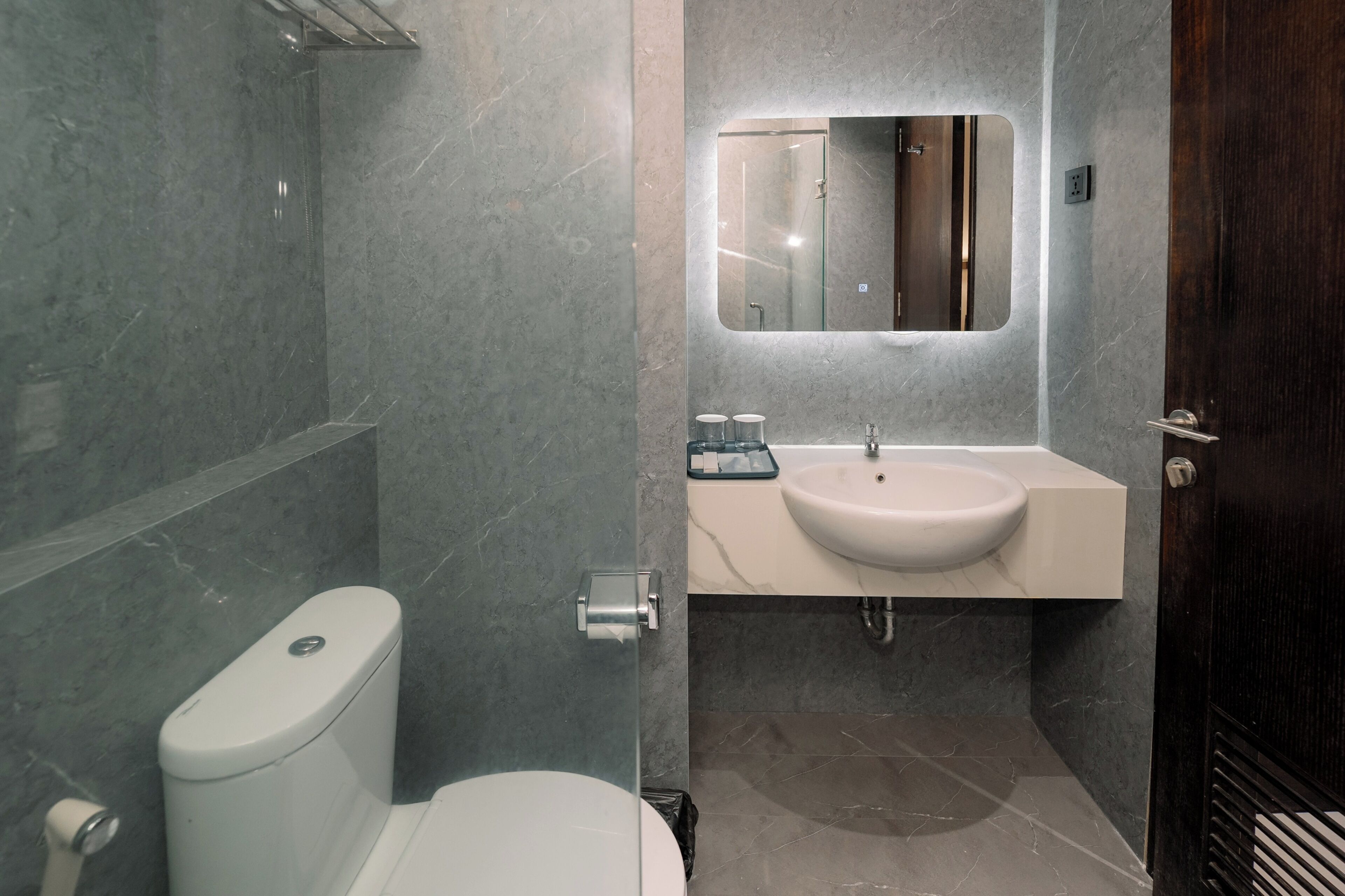 Une salle de bain moderne équipée de toilettes, d’un lavabo et d’une douche.