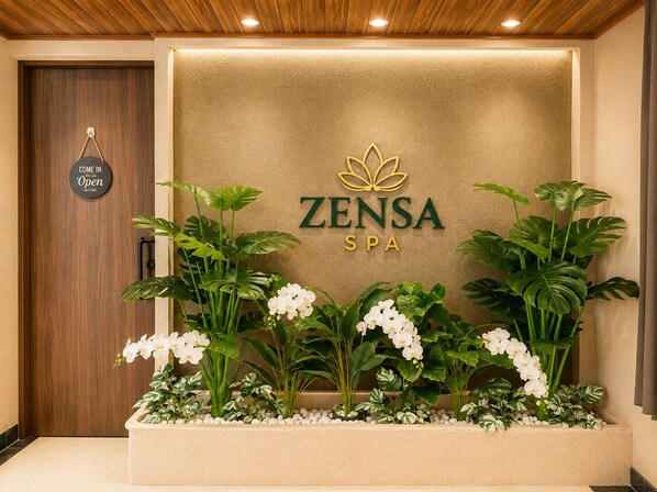 Un espace d’accueil avec une enseigne indiquant « ZENSA SPA » et une autre indiquant « ENTREZ, nous sommes ouverts ».