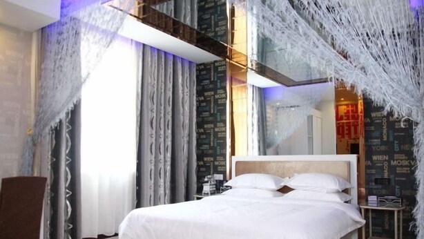 Ein modernes Hotelzimmer mit einem großen Bett, Vorhängen und einer Wand mit Text.
