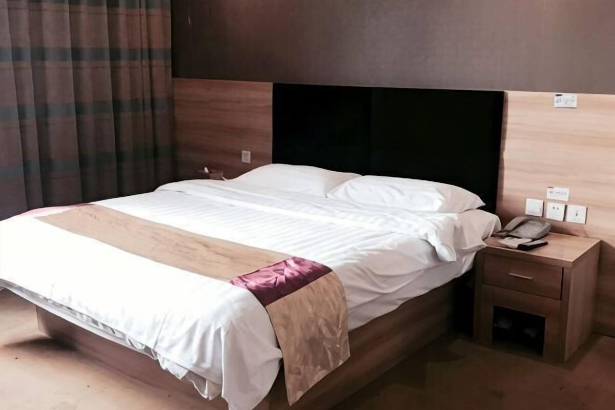 Ein Hotelzimmer mit Bett, Nachttisch und Telefon.