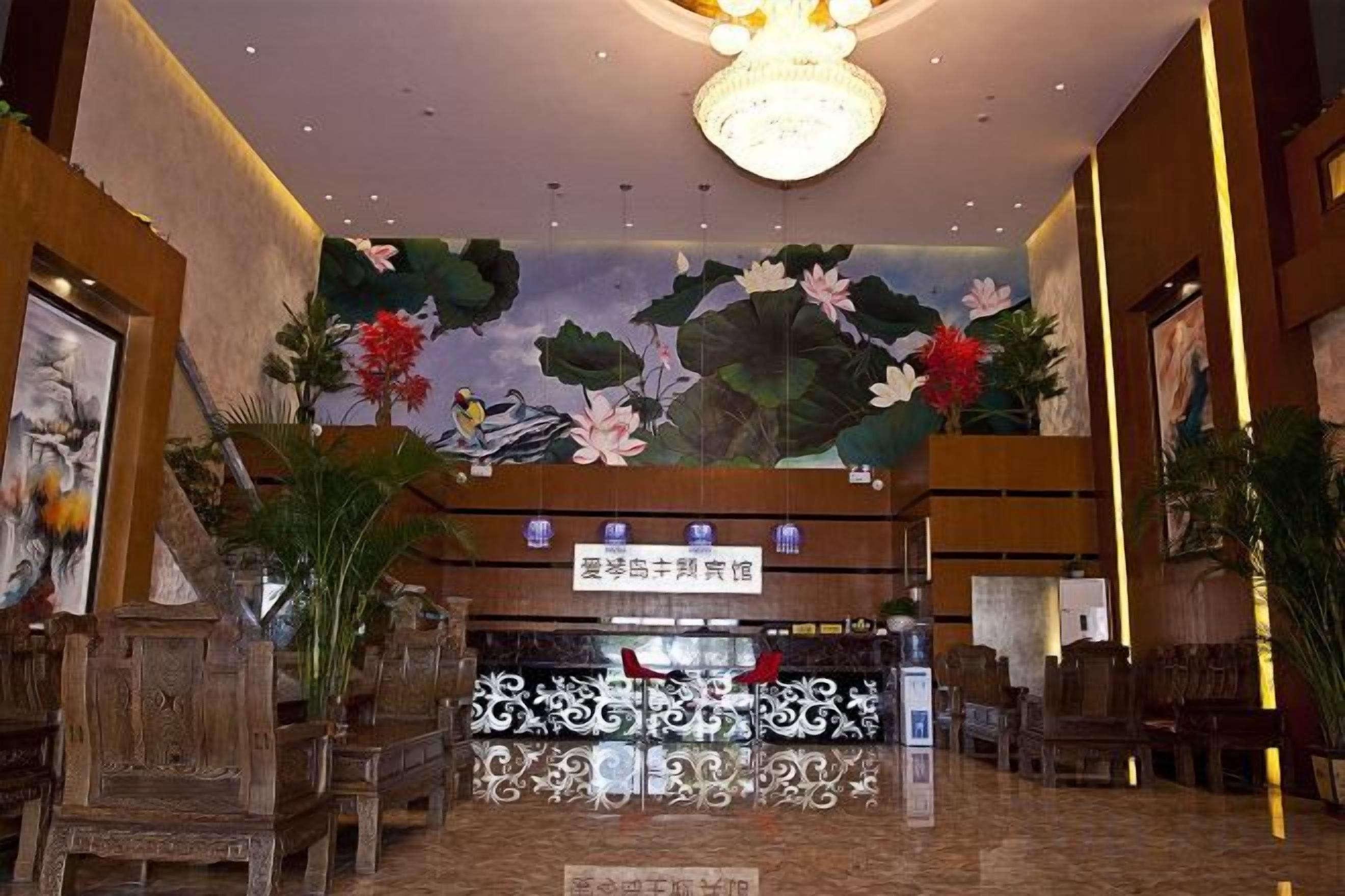A lobby with a reception desk, seating area, and a mural of flowers and birds.
