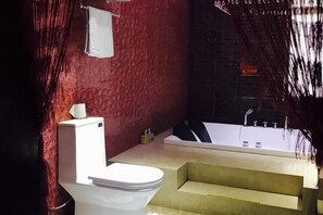 Een badkamer met toilet, bad en douche.