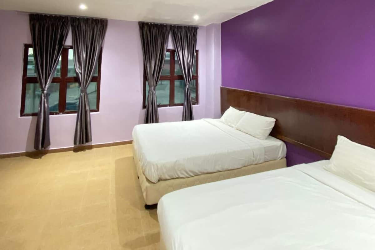 Una habitación de hotel con dos camas, paredes moradas y cortinas en las ventanas.
