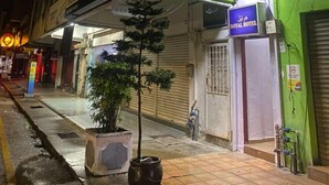 A Royal Hotel with a signboard, a potted plant, and a tiled sidewalk. - ROYAL HOTEL by MR VJ Business (Kuantan)