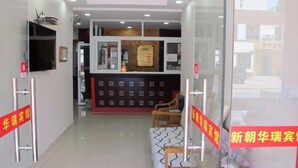 A reception area with a counter, chairs, and a wall-mounted display.
