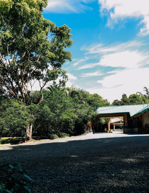 A building with a covered entrance, surrounded by dense greenery and trees. - Hotel el Páramo (Paramo)