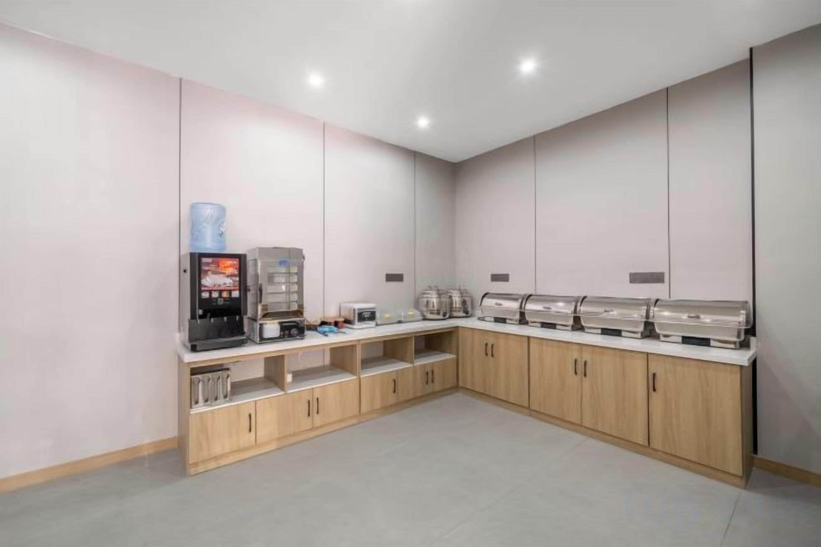 A modern kitchenette with a coffee machine, toaster, and microwave.