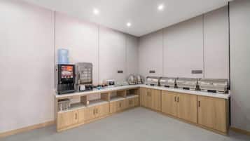 A modern kitchenette with a coffee machine, toaster, and microwave.