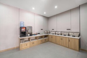 Una kitchenette moderna con cafetera, tostadora y microondas.