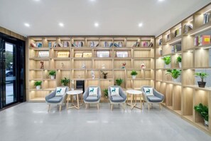 A reception area with a wooden bookshelf, four chairs, and a television.
