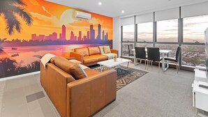 Ein moderner Arbeitsbereich mit einer Stadt-Panoramabildwand, Ledersofas, einem Couchtisch und Blick auf die Stadt durch große Fenster.