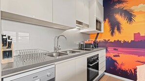 Eine moderne Küche mit Geschirrspüler, einer doppelten Spüle und einer Kaffeemaschine.