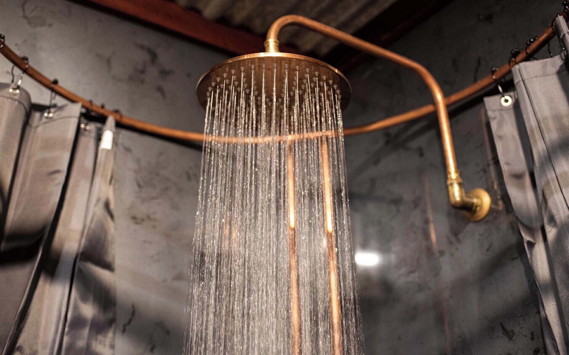 A shower with a curved design and a visible water flow.