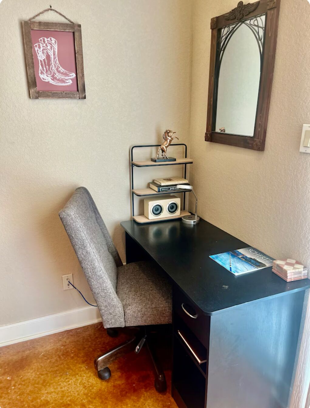 A compact office space with a desk, chair, shelves, and a mirror.