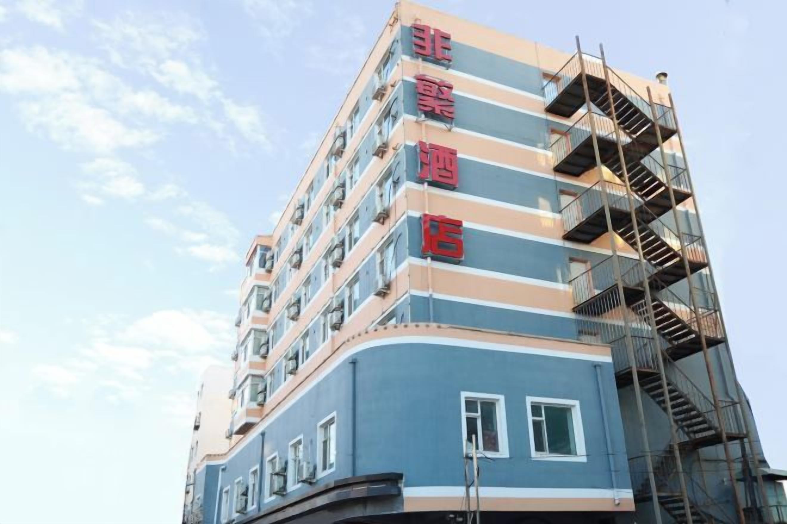 A multi-story hotel building with a blue facade and red signage.