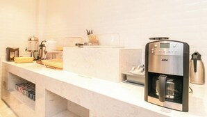 A modern kitchen with a coffee machine, a kettle, and a coffee press on the counter. - Chonpines Hotel (Shengyang Provincial Government, Changjiang North Street, Beilin) (Shenyang)