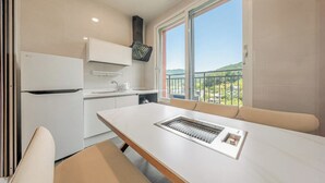 A modern kitchen with a built-in stove, a sink, and a window with a view of the outdoors. - Gapyeong Reflex Pool Villa Pension (Gapyeong)