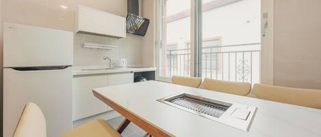 A modern kitchen with a built-in oven, a sink, and a window with a balcony view.