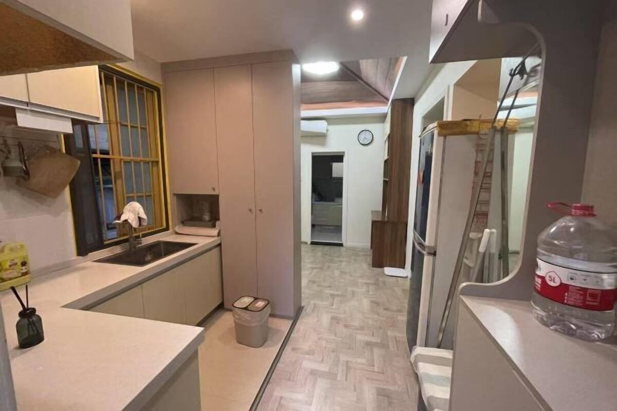 A modern kitchen with a built-in oven, a sink, and a trash bin.