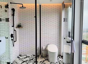 A modern bathroom with a shower, toilet, and a glass-enclosed shower area.