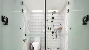 A modern bathroom with white subway tiles, a black shower enclosure, and a toilet.