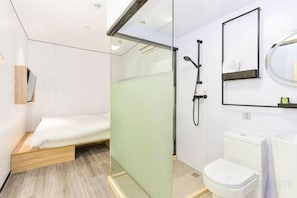 A modern bathroom with a shower, toilet, and a small bed area. - Changee Hotel MINI (Shanghai Pudong Jinqiao Road Subway Station) (Shanghai)