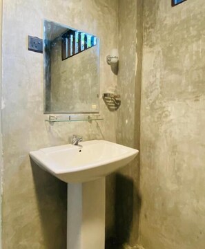 A bathroom with a white pedestal sink, a mirror, and a towel rack. - The Horizon Breeze (Ahangama)