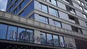 A high-rise hotel with a modern facade, featuring a prominent signage for 'Wanda Moments.'