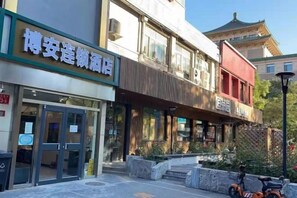 A hotel with a traditional architectural style, featuring a prominent entrance and a covered outdoor seating area. - Beijing Bo'an Chain Hotel (Sanlihe Children's Hospital) (Beijing)