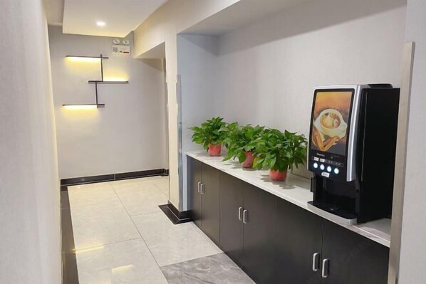A modern hotel lobby with a reception desk, potted plants, and a digital kiosk. - Beijing Bo'an Chain Hotel (Sanlihe Children's Hospital) (Beijing)