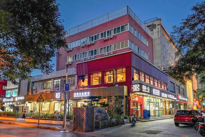 A multi-story building with commercial establishments on the ground floor, including a restaurant and a shop with signage in a foreign language.