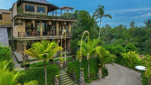 A two-story building with a balcony and a covered patio area. - Hoshi Jungle Resort by Dhananjaya Hospitality (Tegallalang)