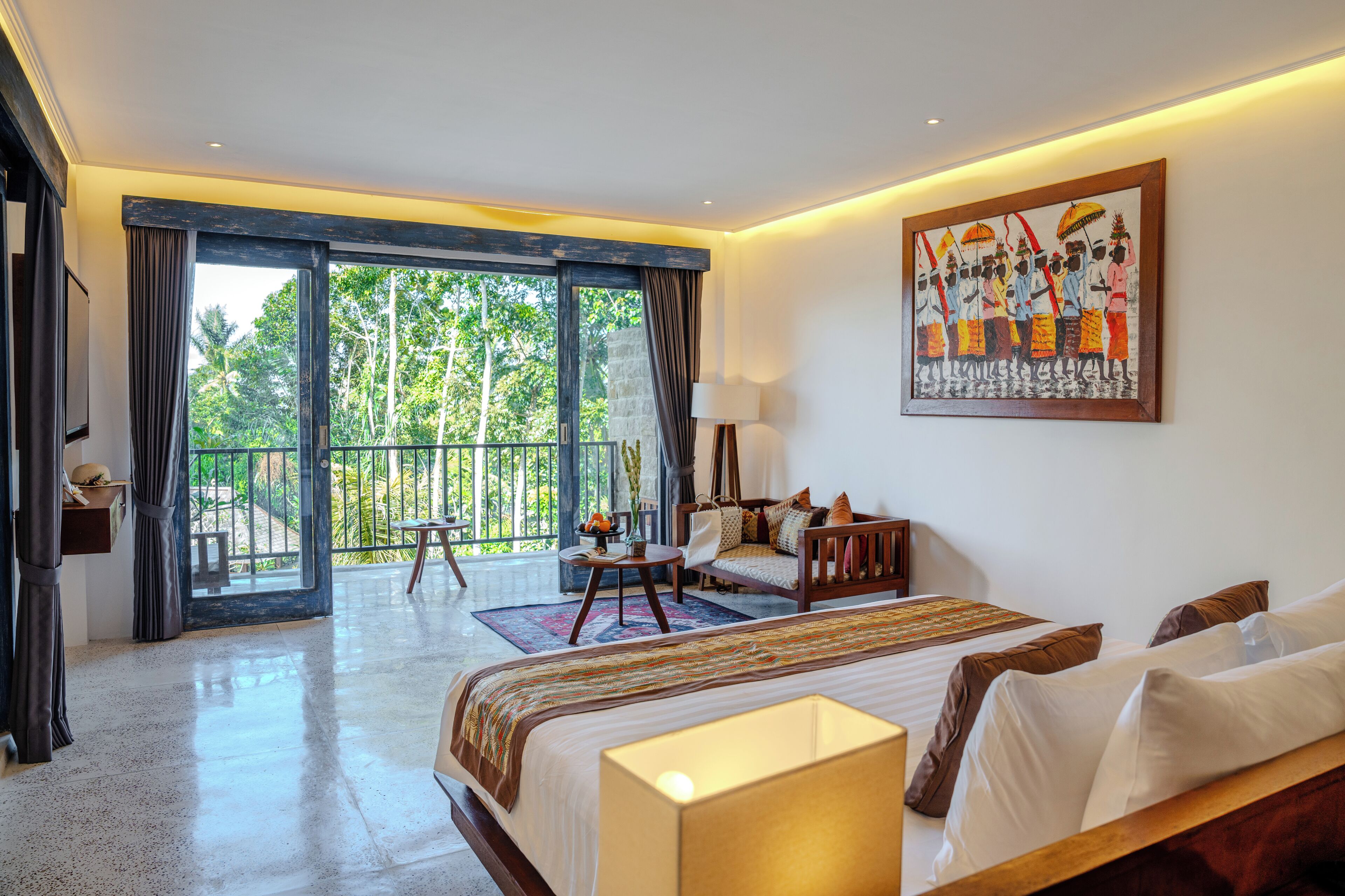 A spacious bedroom with a large bed, a balcony, and a painting on the wall.
