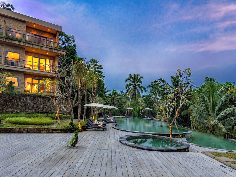 A resort with a pool area, lounge chairs, and a building with multiple balconies.