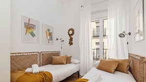 A room with two beds, white bedding, and a window with a view of a balcony. - Malasaña Gold (Madrid)