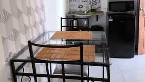 Una cocina moderna con una mesa de comedor, sillas, microondas y refrigerador.