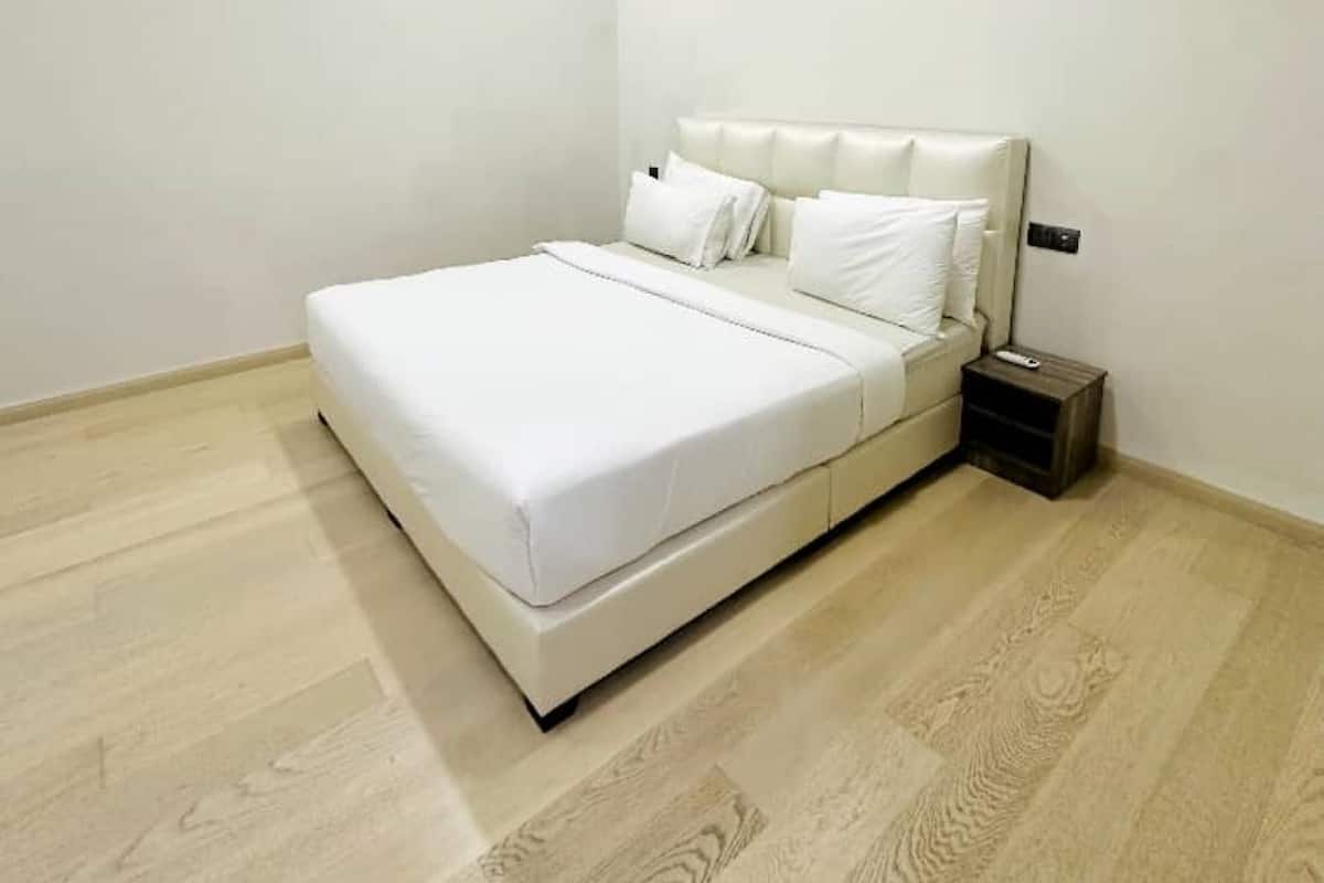 A bedroom with a bed, a nightstand, and a ceiling fan.