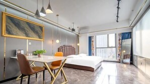 A modern hotel room with a large bed, a dining table with chairs, a desk with a chair, and a large window with curtains. - Jinmei Hotel (Yuhua Wanda) (Shijiazhuang)