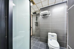 Une salle de bain moderne équipée de toilettes, d’une douche et d’un porte-serviettes.