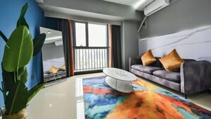 A modern living room with a sofa, coffee table, and a large plant. - Jinmei Hotel (Yuhua Wanda) (Shijiazhuang)