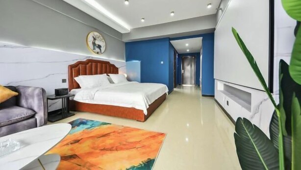Une chambre d’hôtel moderne équipée d’un lit, d’un canapé, d’une télévision et d’un bureau.