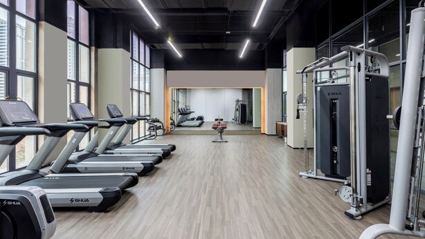 A gym with treadmills, weight machines, and a mirrored wall. - Wanda Moments Neo Nanchang West Railway (Nanchang)