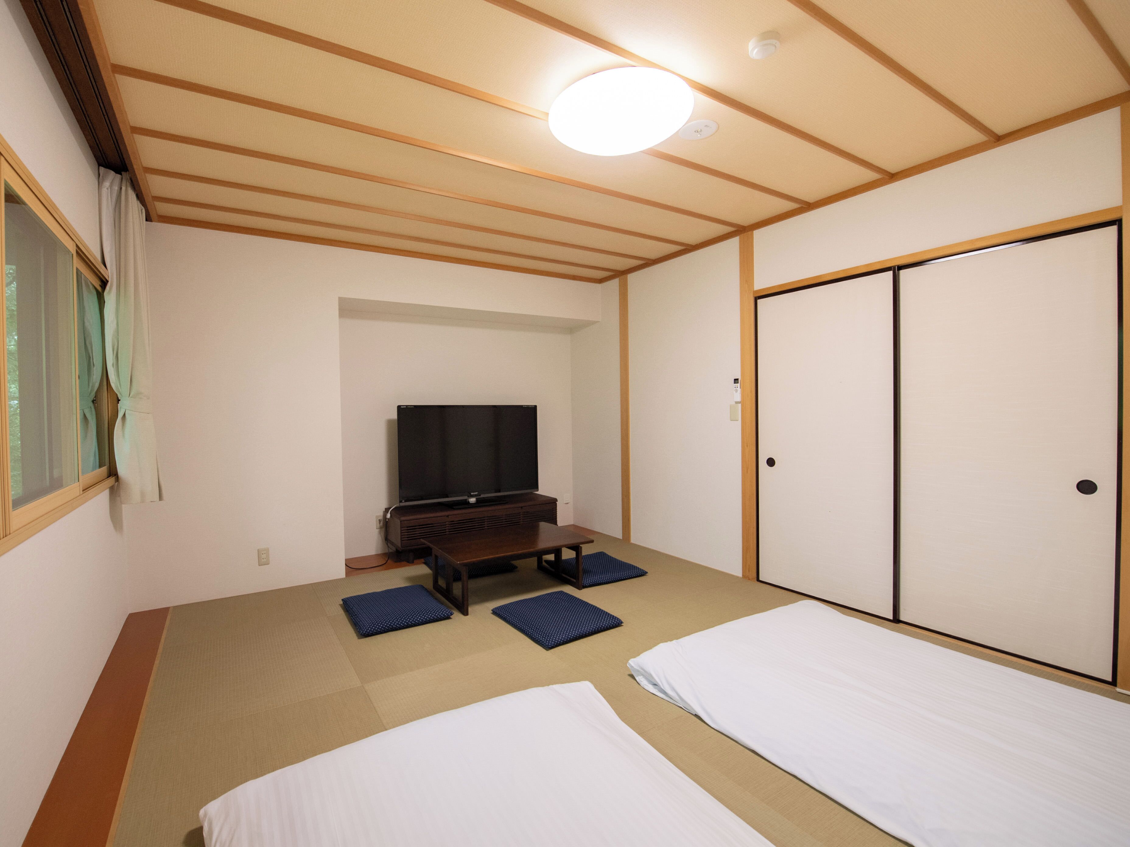 Une chambre avec un lit, une télévision et une armoire.