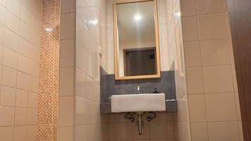 A bathroom with a toilet, sink, and mirror.