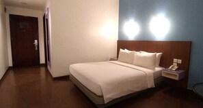 Relax in a cozy space with a comfortable bed, bedside table, and convenient telephone.