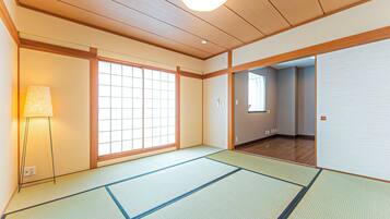 A traditional Japanese room with tatami flooring, sliding doors, and a shoji screen.