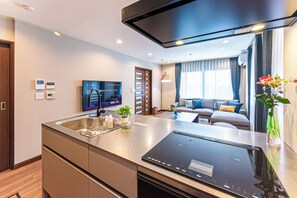 Una cocina moderna con estufa integrada, un lavamanos y un televisor de pantalla plana.